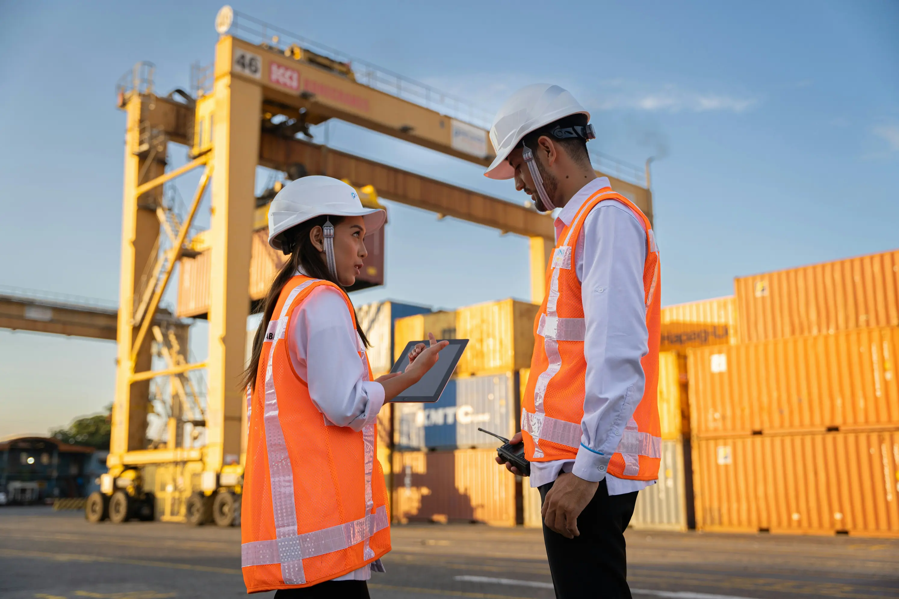 Port workers with tablet at terminal